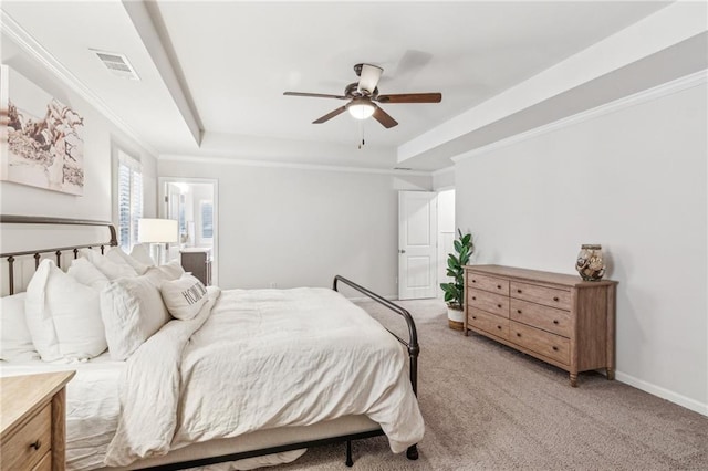 bedroom with a tray ceiling, light carpet, visible vents, and crown molding