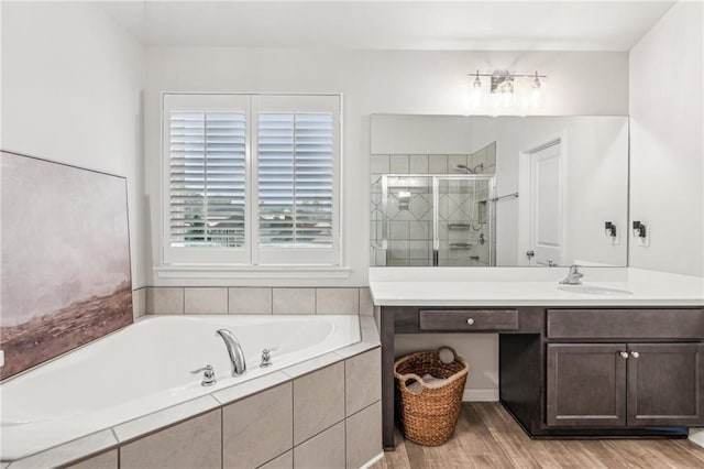 bathroom featuring vanity, a bath, wood finished floors, and a stall shower