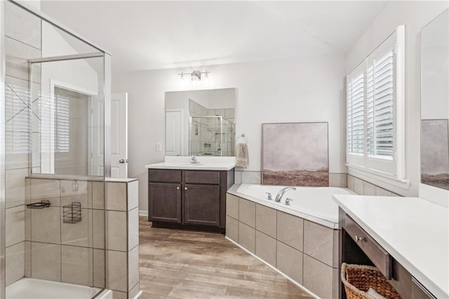 full bath featuring vanity, wood finished floors, a shower stall, and a bath