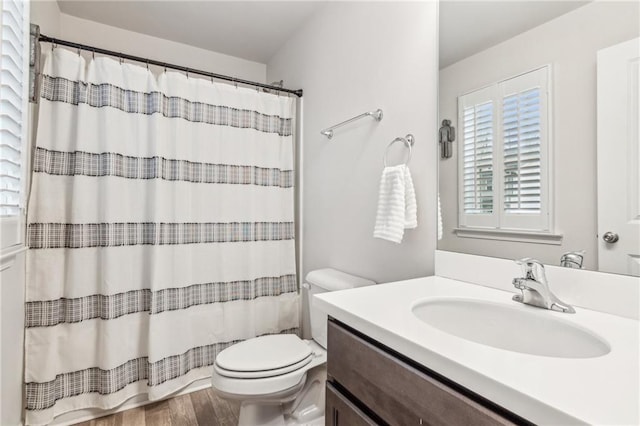 bathroom with vanity, a shower with shower curtain, toilet, and wood finished floors