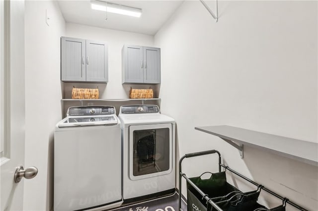 clothes washing area featuring cabinet space and independent washer and dryer