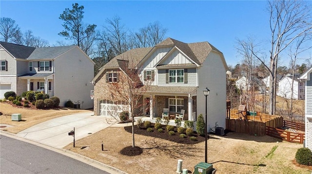 view of front of home featuring board and batten siding, a residential view, covered porch, a garage, and driveway