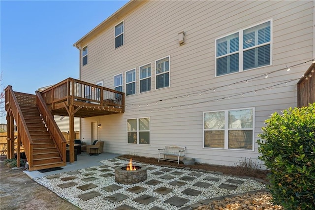 rear view of property featuring stairway, a patio, a deck, and an outdoor fire pit