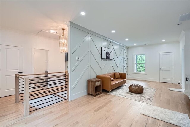 2625 Beverly Ln, Snellville, GA 30078 - sitting room with an upstairs landing, a decorative wall, crown molding, light wood-style flooring, and recessed lighting