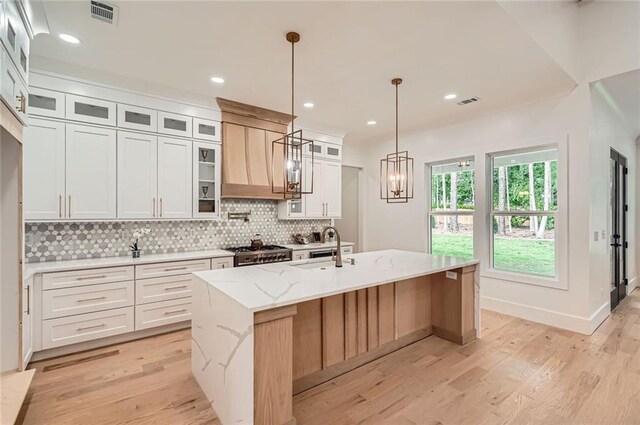 2625 Beverly Ln, Snellville, GA 30078 - kitchen featuring light wood-type flooring, a sink, a kitchen island with sink, decorative backsplash, and recessed lighting