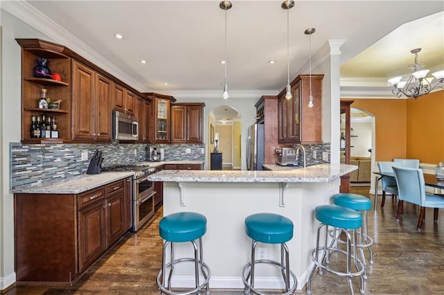 kitchen featuring stainless steel appliances, arched walkways, a peninsula, and open shelves