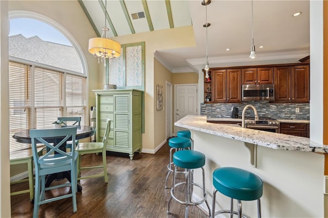 kitchen with stainless steel appliances, decorative backsplash, light stone countertops, dark wood finished floors, and crown molding