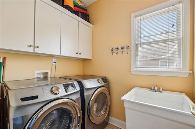 laundry area featuring cabinet space, a sink, and independent washer and dryer