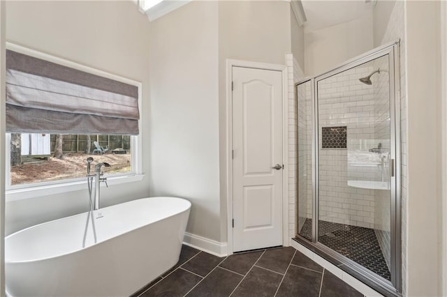 full bathroom featuring baseboards, a soaking tub, a shower stall, and tile patterned floors