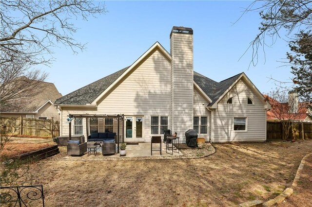 rear view of property with a patio, a fenced backyard, an outdoor hangout area, french doors, and a chimney