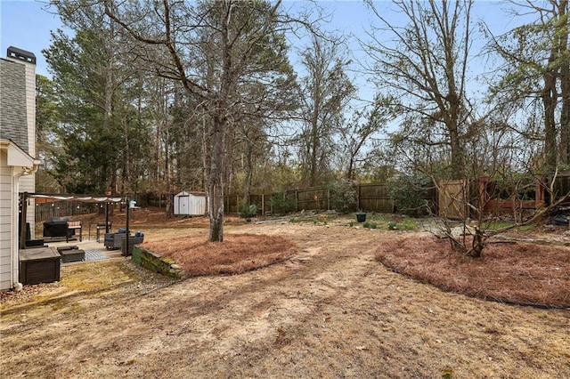 view of yard with an outbuilding, a fenced backyard, and a storage shed