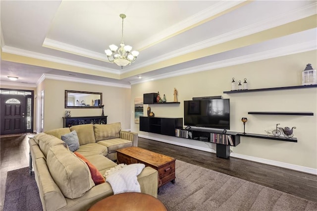 living area with ornamental molding, wood finished floors, a raised ceiling, and a notable chandelier