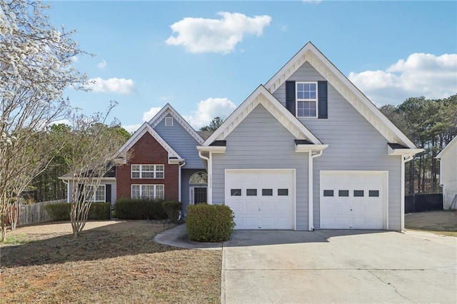 traditional home featuring driveway, a garage, and fence