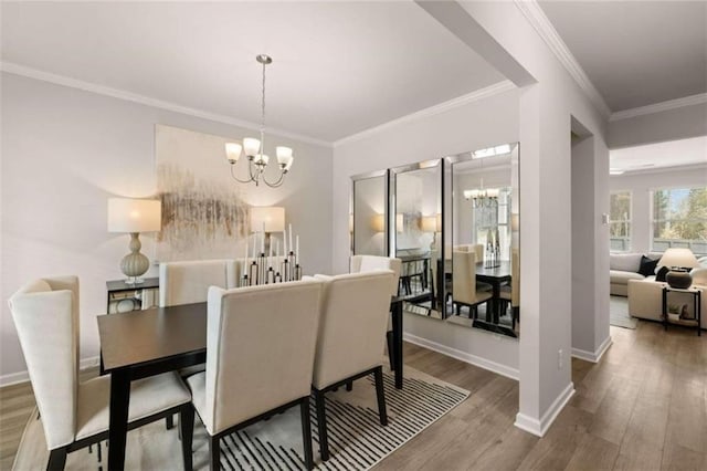 dining space with crown molding, wood-type flooring, and an inviting chandelier