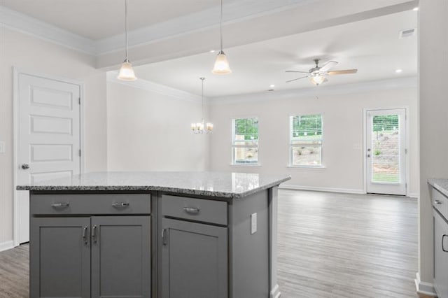 kitchen with crown molding, a kitchen island, hanging light fixtures, and gray cabinetry