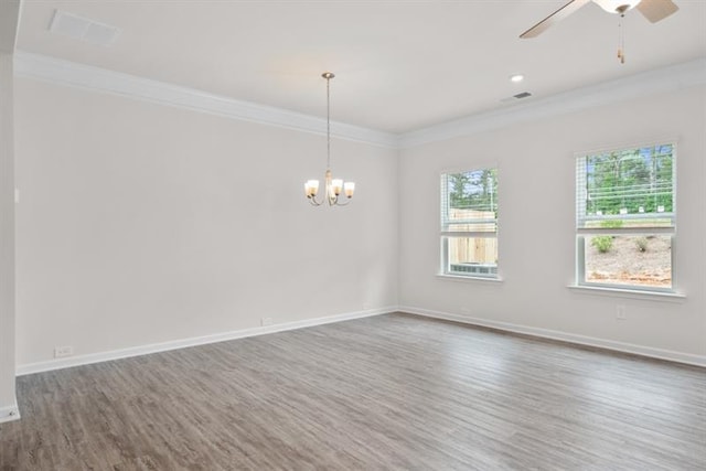 empty room featuring hardwood / wood-style flooring, ornamental molding, and ceiling fan with notable chandelier