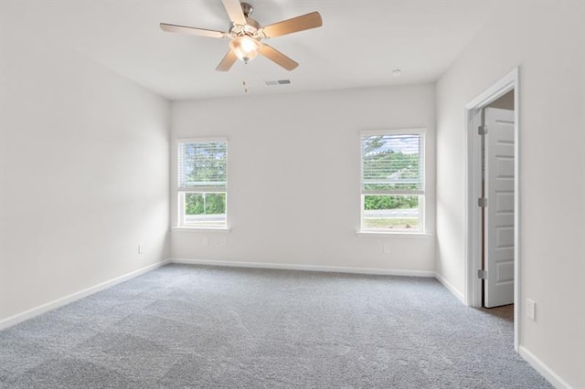 carpeted spare room with ceiling fan