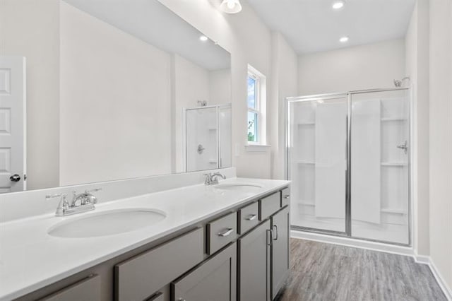 bathroom featuring a shower with door, vanity, and hardwood / wood-style flooring