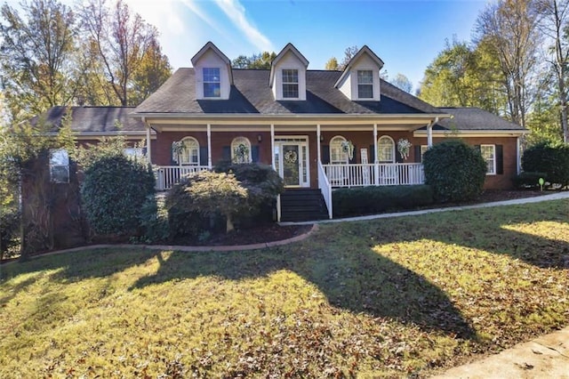 cape cod home with covered porch and a front lawn