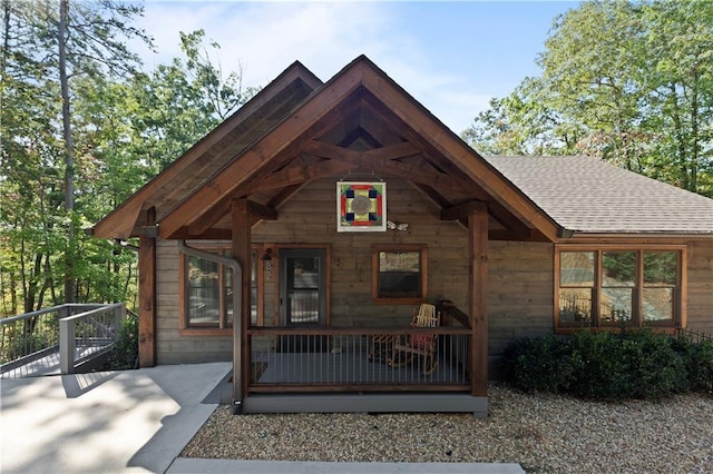 view of front of house with a shingled roof and a porch