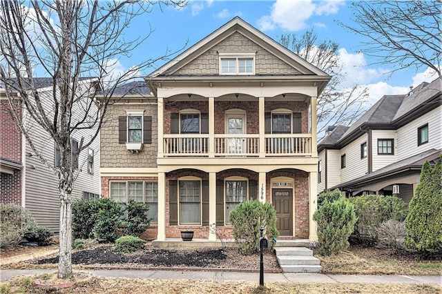 view of front of property featuring brick siding, a porch, and a balcony