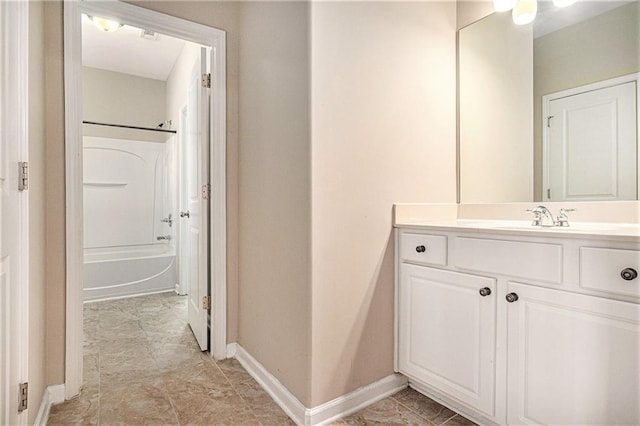 full bathroom with washtub / shower combination, baseboards, and vanity