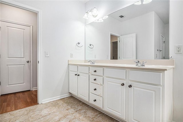 full bathroom with visible vents, a sink, baseboards, and double vanity