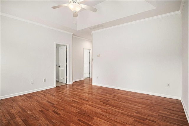 empty room with wood finished floors, crown molding, a ceiling fan, and baseboards