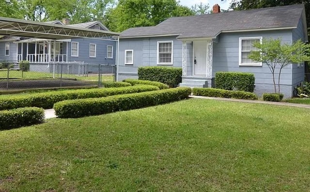 view of front facade featuring a chimney, fence, and a front lawn