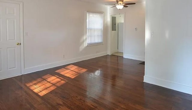 unfurnished room featuring ceiling fan, electric panel, baseboards, and wood finished floors