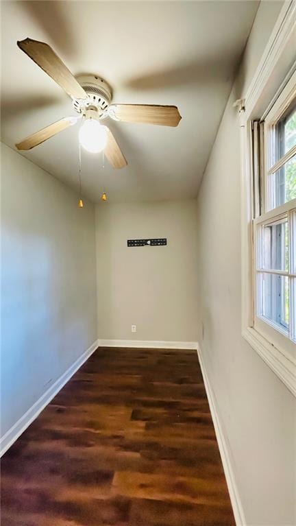 unfurnished room featuring a ceiling fan, baseboards, and wood finished floors