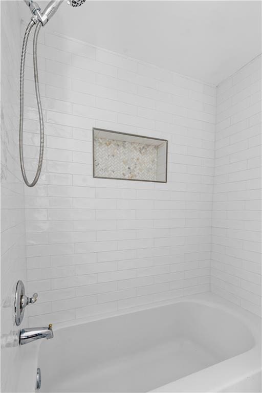 bathroom featuring tiled shower / bath