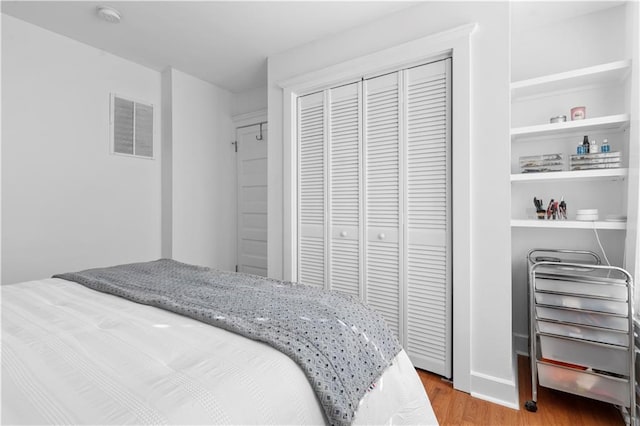 bedroom featuring wood-type flooring and a closet