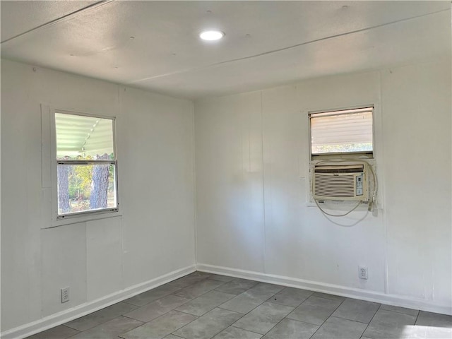 tiled spare room featuring a wealth of natural light and cooling unit