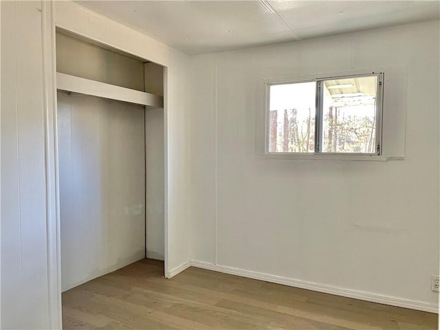 unfurnished bedroom featuring light hardwood / wood-style floors and a closet