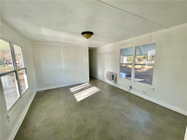 unfurnished room featuring a wall mounted air conditioner and plenty of natural light