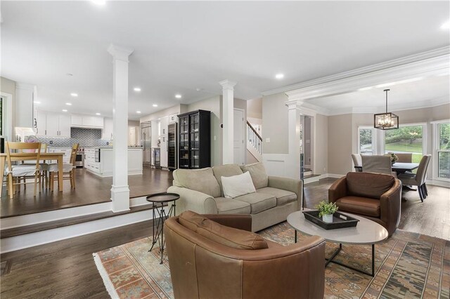 660 Willow Knoll Dr SE, Marietta, GA 30067 - living room with ornate columns, dark wood-type flooring, crown molding, stairs, and recessed lighting