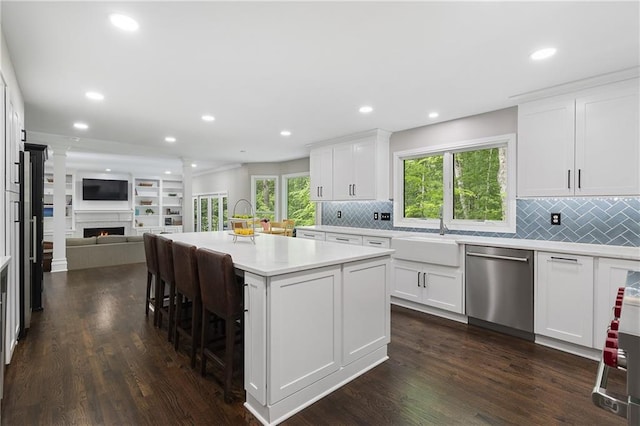 660 Willow Knoll Dr SE, Marietta, GA 30067 - kitchen featuring stainless steel dishwasher, a sink, open floor plan, a lit fireplace, and dark wood-style flooring