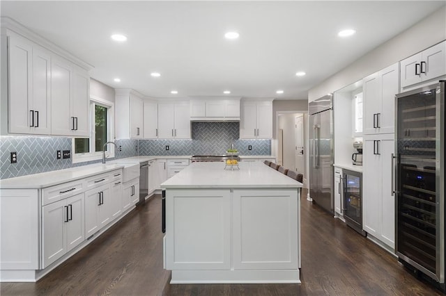 660 Willow Knoll Dr SE, Marietta, GA 30067 - kitchen with beverage cooler, stainless steel appliances, light countertops, a kitchen island, and recessed lighting