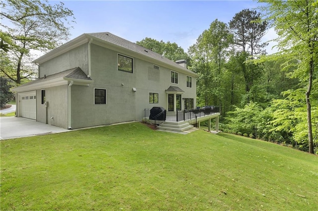 660 Willow Knoll Dr SE, Marietta, GA 30067 - rear view of property with stucco siding, a deck, a yard, driveway, and an attached garage