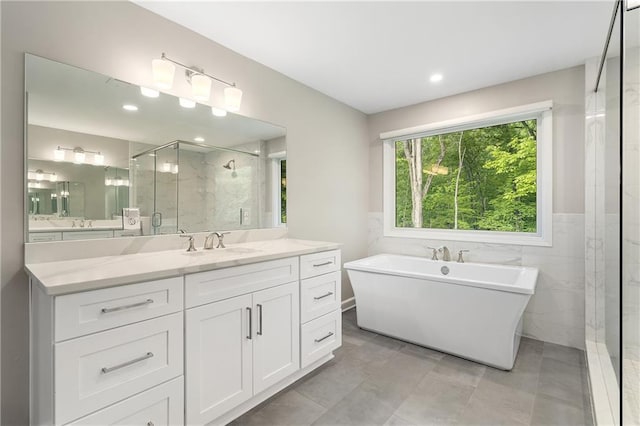 660 Willow Knoll Dr SE, Marietta, GA 30067 - bathroom featuring a stall shower, a soaking tub, vanity, tile walls, and wainscoting
