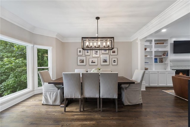 660 Willow Knoll Dr SE, Marietta, GA 30067 - dining area featuring a chandelier, crown molding, dark wood-style flooring, and a brick fireplace