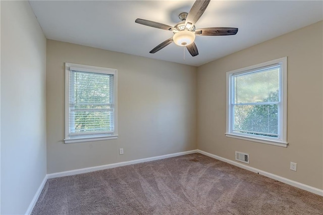 carpeted spare room with ceiling fan