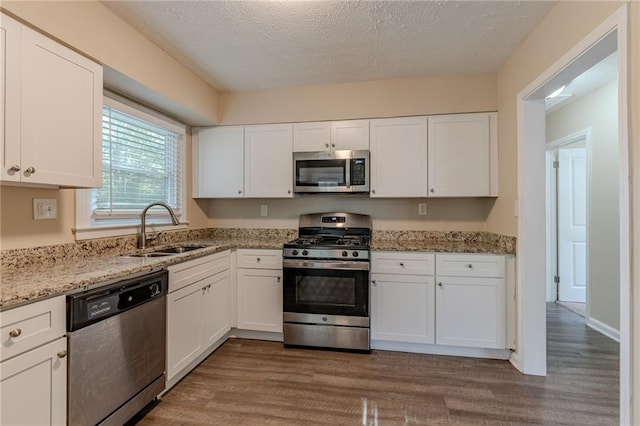 kitchen featuring white cabinets, appliances with stainless steel finishes, dark hardwood / wood-style flooring, and a textured ceiling