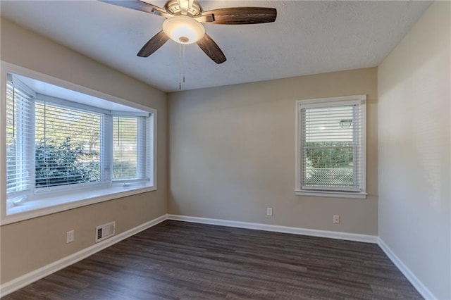 spare room with ceiling fan, dark wood-type flooring, and a textured ceiling