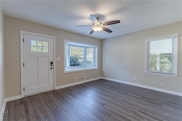 foyer entrance featuring ceiling fan, dark hardwood / wood-style flooring, and a textured ceiling