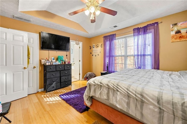 bedroom featuring wood finished floors, lofted ceiling, ceiling fan, and connected bathroom