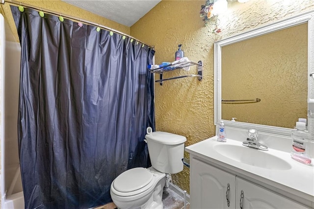 bathroom with a textured wall, toilet, vanity, and a textured ceiling