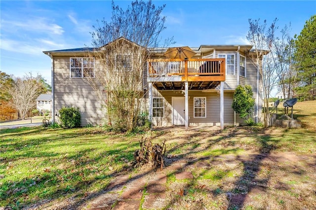 back of house with a wooden deck and a lawn