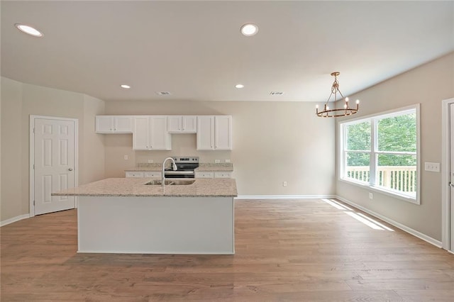 175 W Woods Dr, Dahlonega, GA 30533 - kitchen featuring a sink, white cabinetry, a chandelier, baseboards, and light wood-style flooring